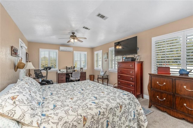 carpeted bedroom with baseboards, visible vents, a wall mounted air conditioner, and ceiling fan