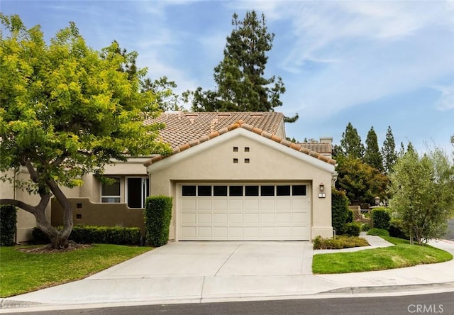 mediterranean / spanish-style home with stucco siding, a front lawn, concrete driveway, and an attached garage
