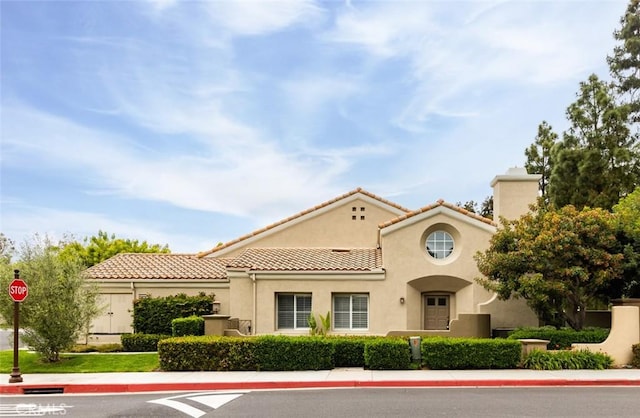 view of front of house with a tile roof and stucco siding