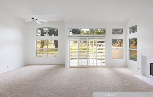 interior space with carpet flooring, a tiled fireplace, and a healthy amount of sunlight