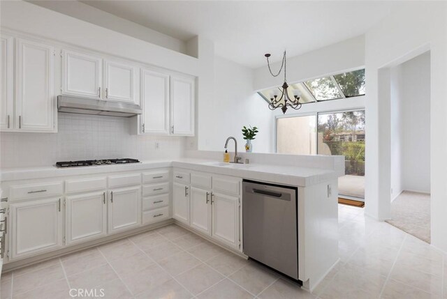 kitchen featuring a sink, gas stovetop, under cabinet range hood, a notable chandelier, and dishwasher