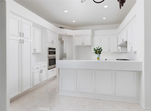 kitchen featuring white cabinets, visible vents, light countertops, stainless steel double oven, and recessed lighting