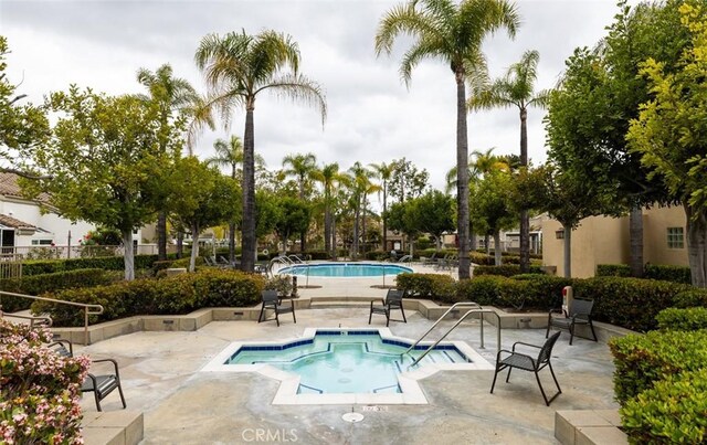 pool featuring a community hot tub and a patio area