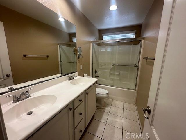 2420 Lenai Cir, Corona, CA 92879 - bathroom featuring combined bath / shower with glass door, double vanity, and tile patterned flooring