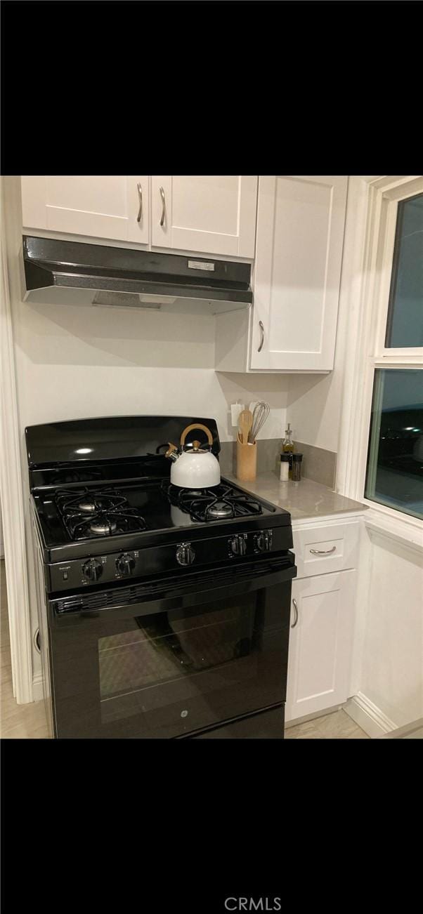 610 E Fairview, Inglewood, CA 90302 - kitchen featuring light countertops, white cabinets, under cabinet range hood, and black gas range oven