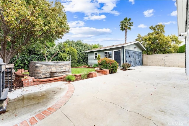 view of patio / terrace featuring a garage, fence, and an outdoor structure