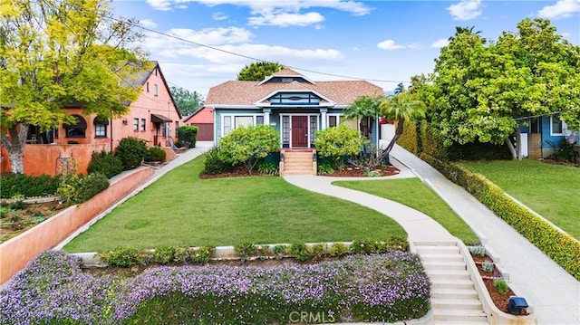 bungalow with a front yard and fence