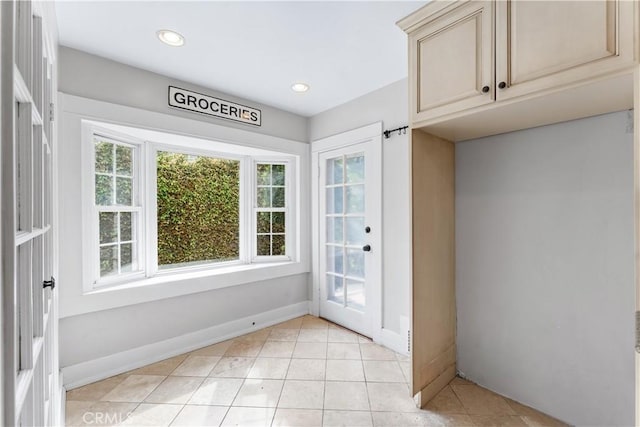 doorway featuring light tile patterned floors, baseboards, and recessed lighting