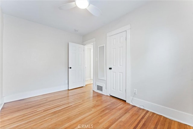 unfurnished bedroom featuring baseboards, visible vents, light wood-style floors, and a ceiling fan