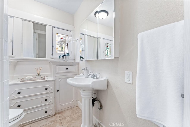 bathroom featuring toilet and tile patterned flooring