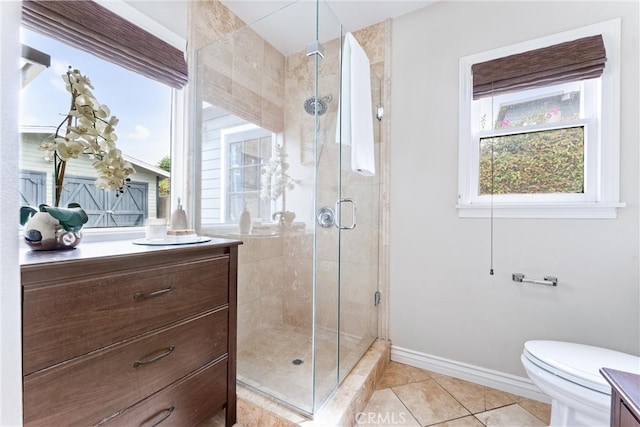 bathroom with toilet, vanity, a shower stall, tile patterned flooring, and baseboards