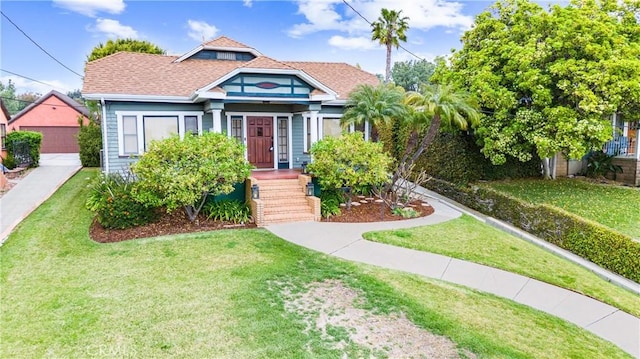 view of front of home with a shingled roof and a front yard