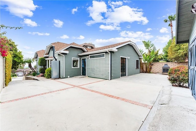 exterior space featuring concrete driveway, fence, and a patio area