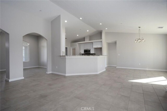 17796 Valencia St, Hesperia, CA 92345 - unfurnished living room featuring arched walkways, a chandelier, high vaulted ceiling, baseboards, and recessed lighting