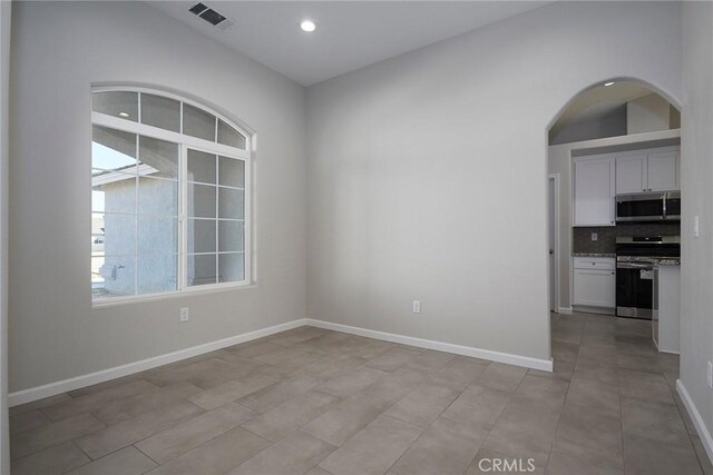 17796 Valencia St, Hesperia, CA 92345 - empty room with arched walkways, baseboards, and recessed lighting