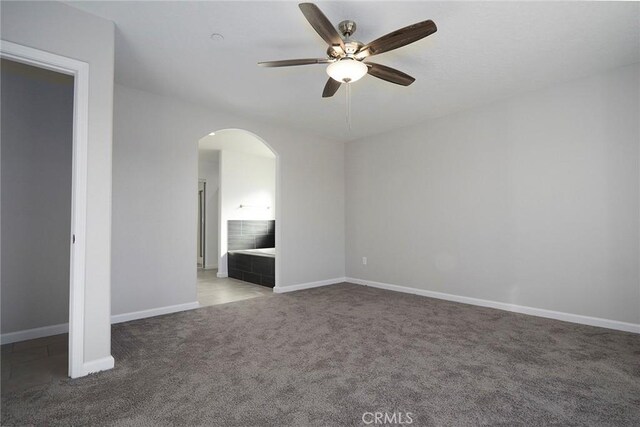 17796 Valencia St, Hesperia, CA 92345 - carpeted empty room featuring arched walkways, a ceiling fan, and baseboards