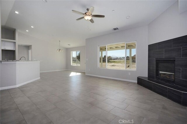 17796 Valencia St, Hesperia, CA 92345 - unfurnished living room featuring lofted ceiling, a chandelier, a tile fireplace, ceiling fan, and baseboards