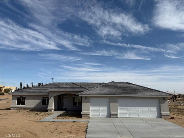 17796 Valencia St, Hesperia, CA 92345 - view of front of property featuring stucco siding, an attached garage, and driveway