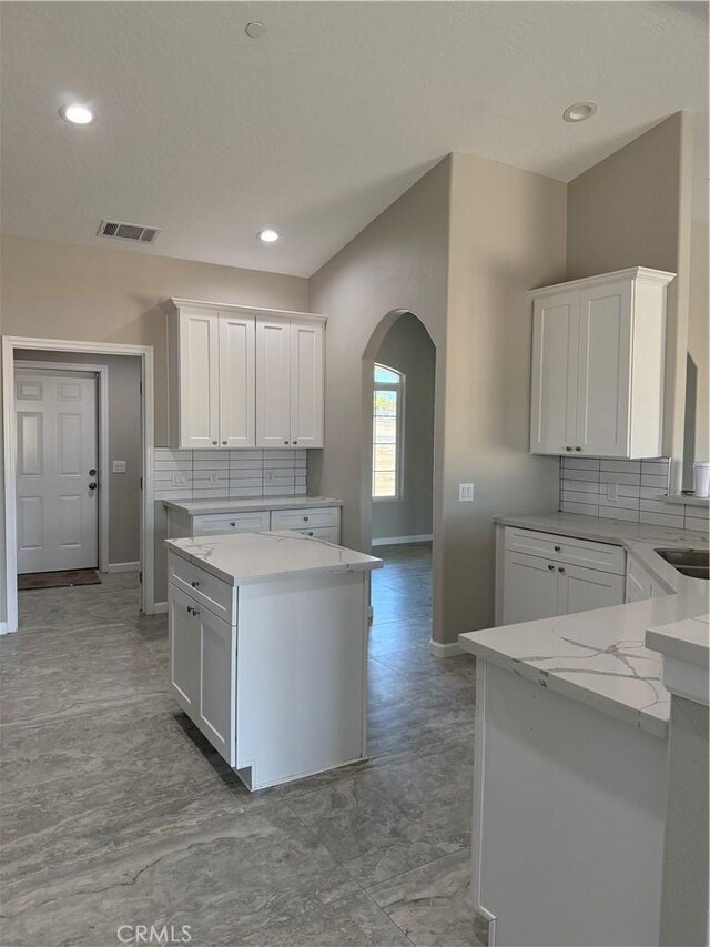 17796 Valencia St, Hesperia, CA 92345 - kitchen with arched walkways, baseboards, white cabinetry, backsplash, and recessed lighting
