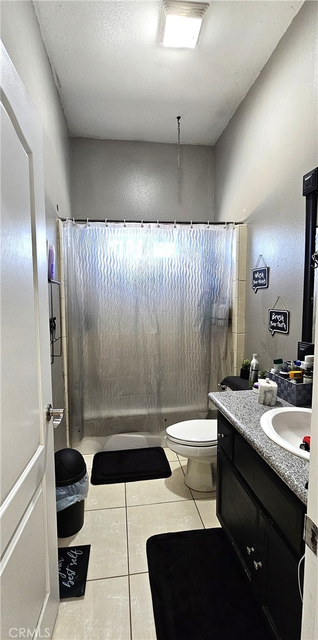 7445 Cedar St, Phelan, CA 92371 - bathroom with toilet, tile patterned floors, a shower with shower curtain, and vanity