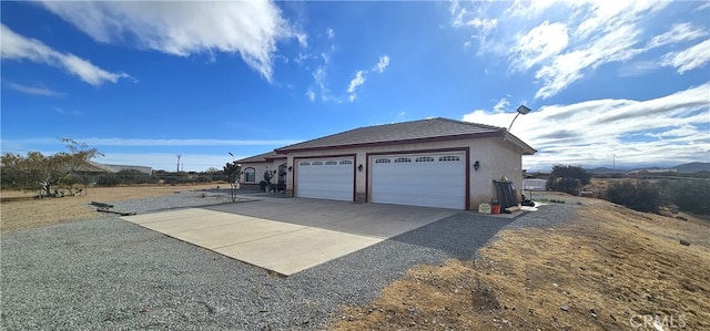 7445 Cedar St, Phelan, CA 92371 - view of side of property with a garage, stucco siding, and driveway