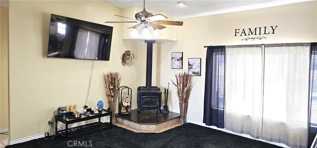 7445 Cedar St, Phelan, CA 92371 - carpeted living area featuring ceiling fan, baseboards, and a wood stove