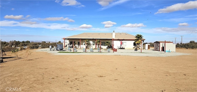7445 Cedar St, Phelan, CA 92371 - back of house featuring a patio, a shed, and an outbuilding