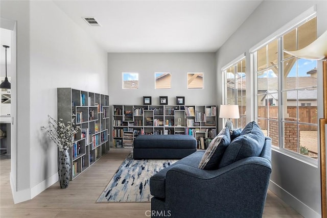living area featuring visible vents, baseboards, and wood finished floors