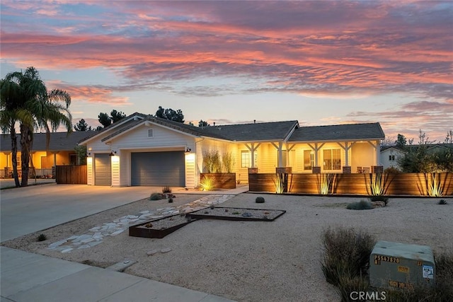 ranch-style house featuring driveway, fence, and an attached garage