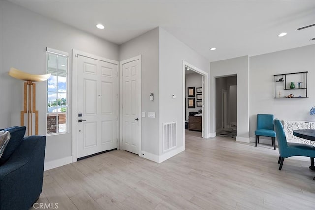 entryway featuring light wood finished floors, baseboards, visible vents, and recessed lighting