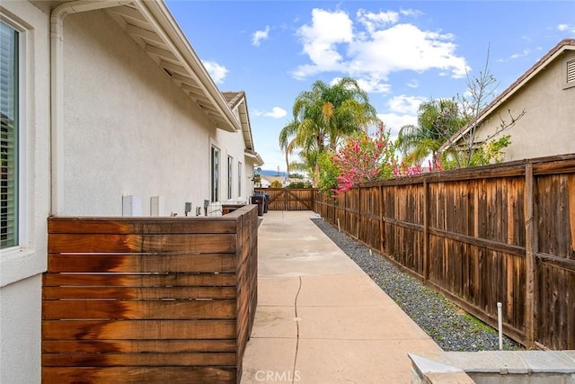 view of side of home with a patio, a fenced backyard, and stucco siding
