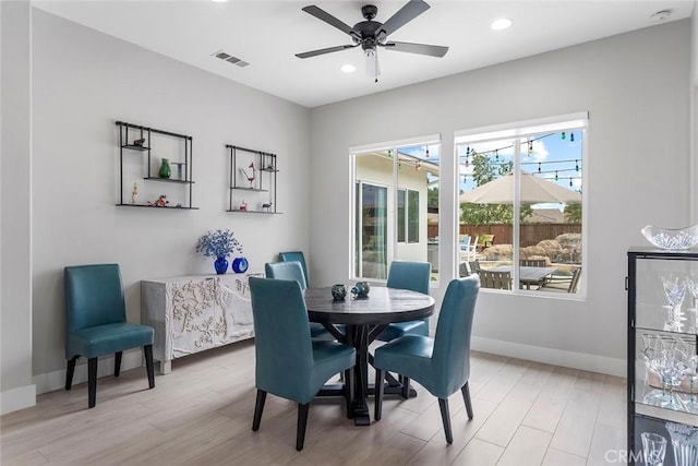 dining area featuring baseboards, visible vents, light wood-type flooring, and a ceiling fan