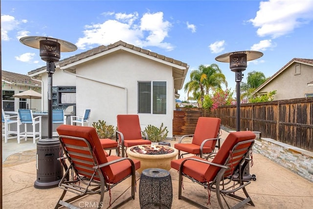 view of patio with an outdoor fire pit and fence