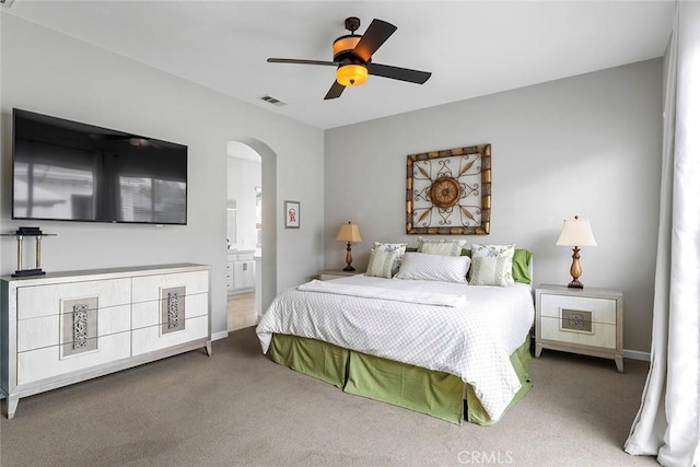 bedroom with visible vents, arched walkways, a ceiling fan, carpet floors, and connected bathroom