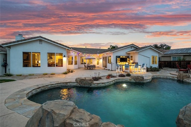 pool with a patio, outdoor dining area, and fence