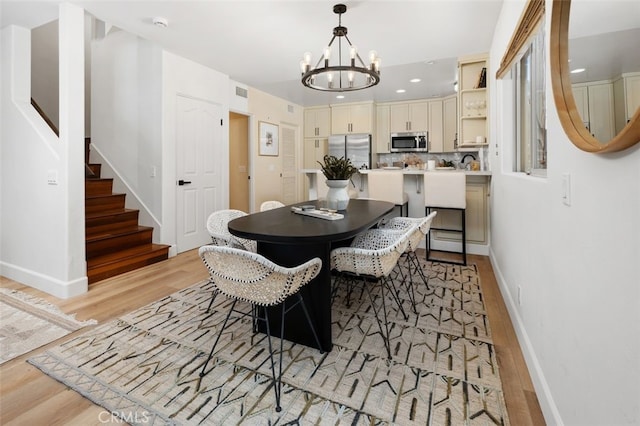 1517 Felspar St, San Diego, CA 92109 - dining area with a chandelier, light wood-style flooring, stairs, baseboards, and recessed lighting
