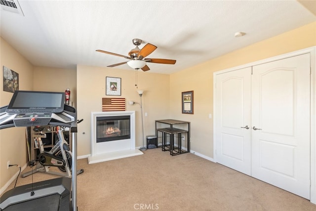 33734 Wild Horse Way, Yucaipa, CA 92399 - workout room with ceiling fan, a glass covered fireplace, carpet flooring, and baseboards