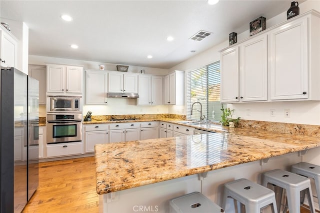 33734 Wild Horse Way, Yucaipa, CA 92399 - kitchen featuring appliances with stainless steel finishes, a peninsula, a sink, white cabinets, and recessed lighting
