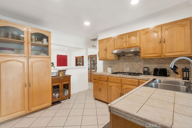 915 S Danehurst Ave, Glendora, CA 91740 - kitchen with under cabinet range hood, tile countertops, a sink, stainless steel gas stovetop, and decorative backsplash