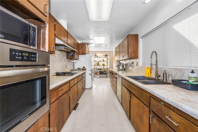 7160 Bel Air St, Corona, CA 92881 - kitchen with stainless steel appliances, a sink, under cabinet range hood, light floors, and light countertops
