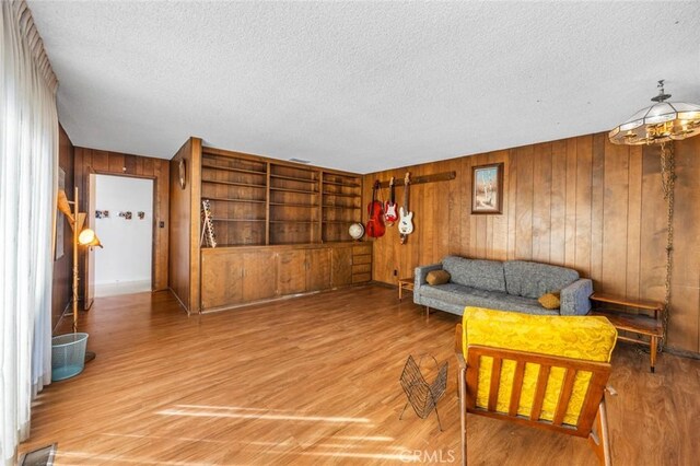 7160 Bel Air St, Corona, CA 92881 - living room with a textured ceiling, light wood finished floors, and wooden walls