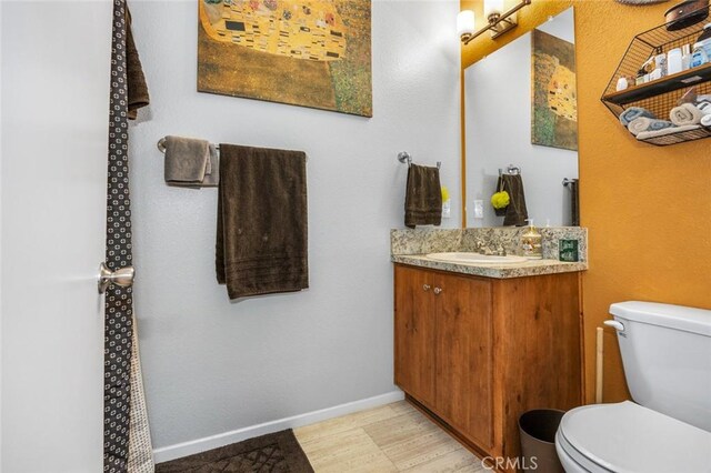 7160 Bel Air St, Corona, CA 92881 - bathroom with toilet, vanity, wood finished floors, and baseboards