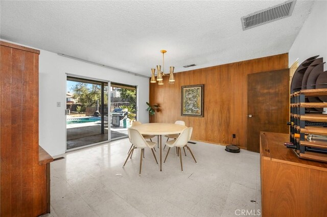 7160 Bel Air St, Corona, CA 92881 - dining area with light floors, wood walls, a chandelier, and a textured ceiling