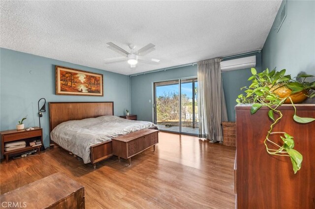 7160 Bel Air St, Corona, CA 92881 - bedroom featuring a wall unit AC, access to outside, a textured ceiling, wood finished floors, and ceiling fan