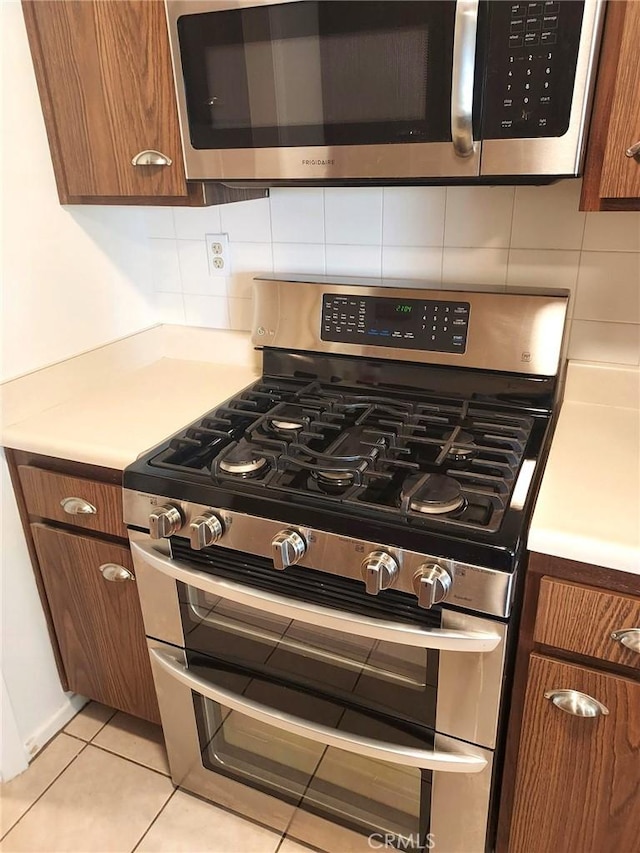 27535 Lakeview Dr Unit 14, Helendale, CA 92342 - kitchen view of stainless steel appliances, brown cabinetry, and backsplash