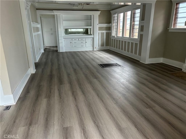 unfurnished living room with dark wood finished floors, baseboards, and visible vents