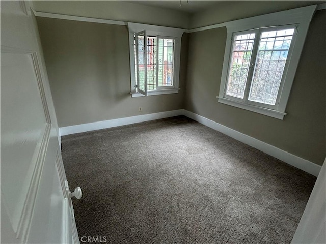 carpeted spare room with baseboards