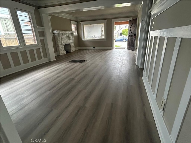 unfurnished living room with visible vents, ornamental molding, baseboards, a fireplace, and dark wood-style flooring