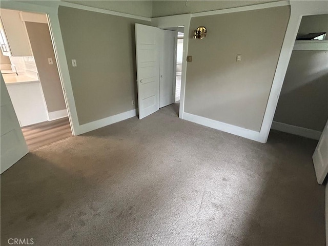 unfurnished bedroom featuring carpet floors and baseboards