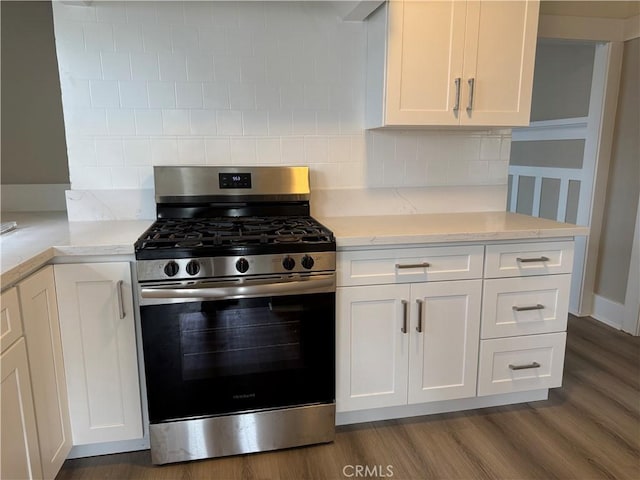 kitchen featuring white cabinets, decorative backsplash, and stainless steel gas range
